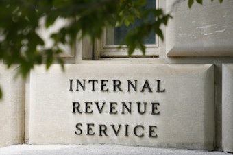 caption: A sign outside the Internal Revenue Service building in Washington, on May 4, 2021. Effective immediately, the Internal Revenue Service will end its decades-old policy of making unannounced home and business visits — in a nod to worker safety and combatting scammers who pose as IRS agents.