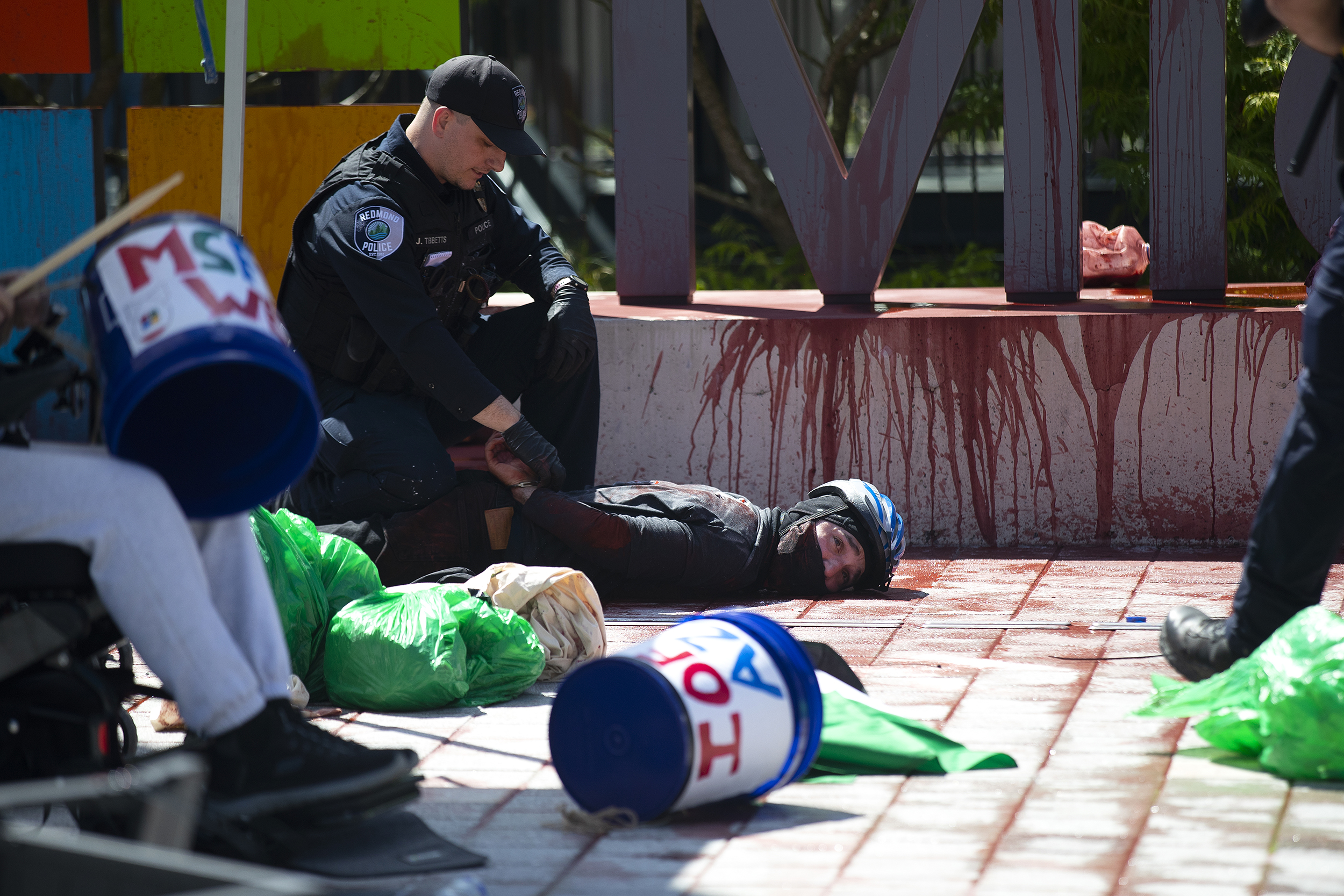 caption: Redmond police officers arrest a  Pro-Palestinian protester after a "liberated zone" that they called The Martyred Palestinian Children’s Plaza, was re-established for the second day in a row, on Wednesday, August 20, 2025, on the Microsoft East Campus Plaza in Redmond. The activists are calling on Microsoft to cut ties with Israel. 