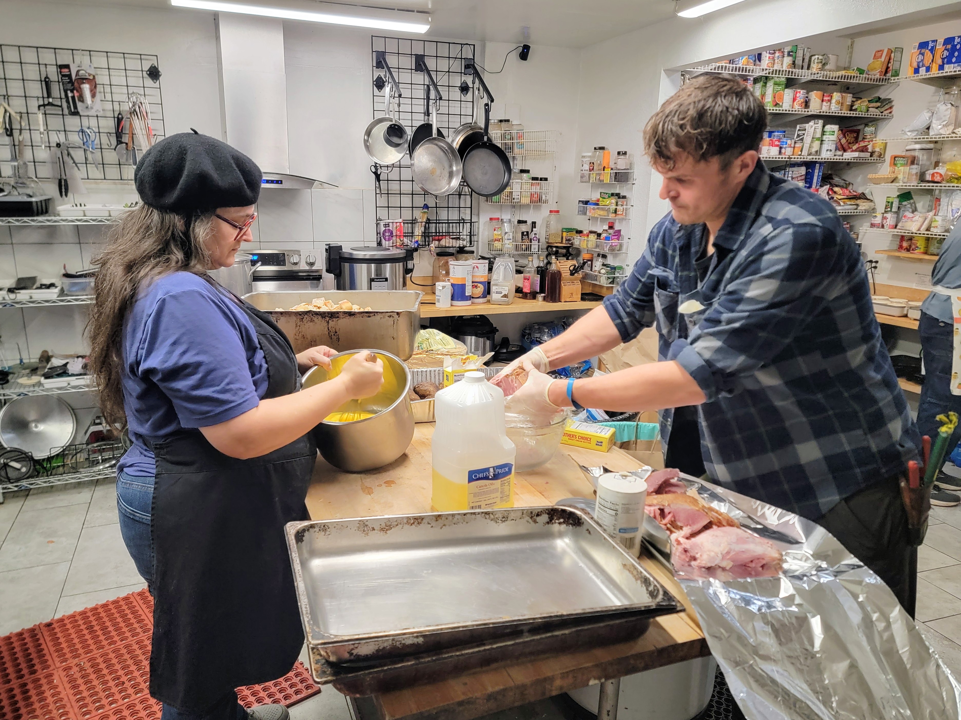 caption: Kitchen volunteers Hayla Thompson (left) and Tim James say they often don't know what they'll make for breakfast until they see what food is available that morning. 