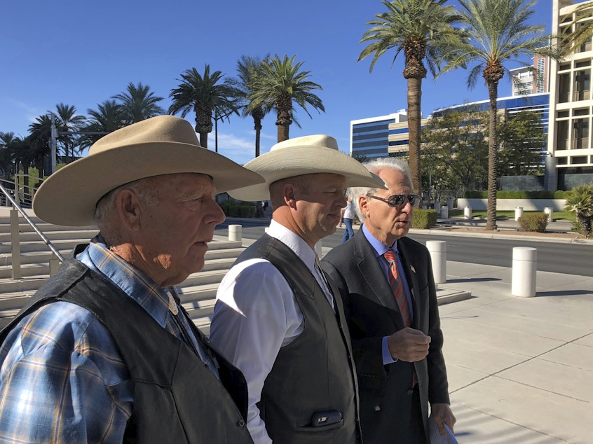 caption: A federal appeals court has confirmed the dismissal of a criminal case against Nevada rancher Cliven Bundy (left), seen in 2018 with his son Ryan Bundy and attorney Larry Klayman.