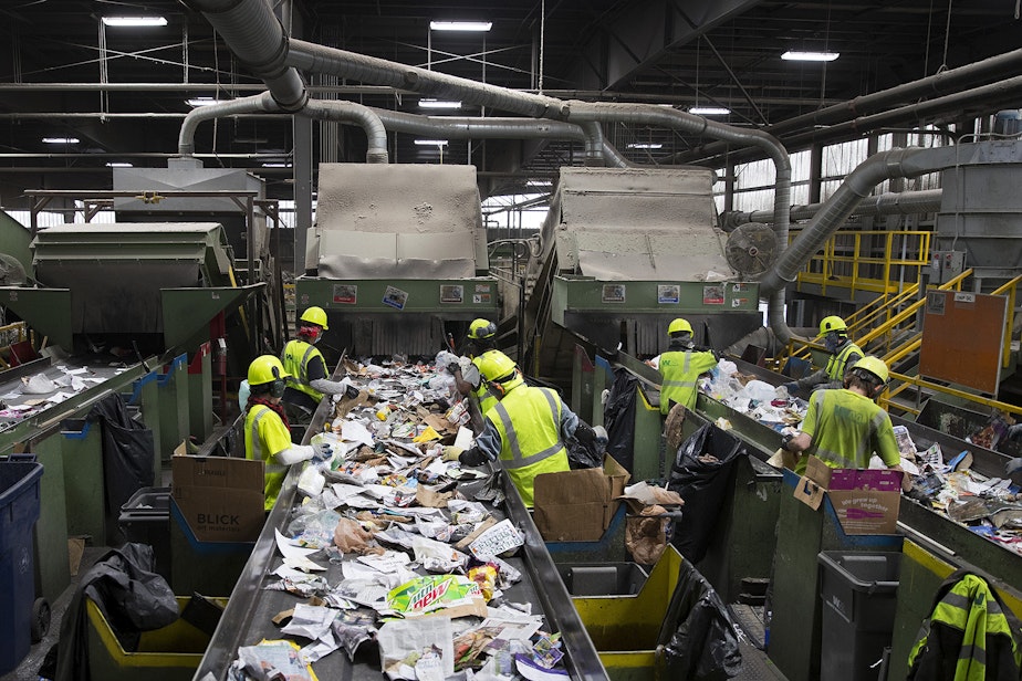 caption: Employees remove items that cannot be recycled from a conveyer belt on Friday, October 26, 2018, at Cascade Recycling Center in Woodinville. 