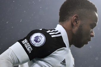 caption: A "No room for racism" logo and Premier League logo is seen on the shirt of Ademola Lookman of Fulham during the Premier League match.
