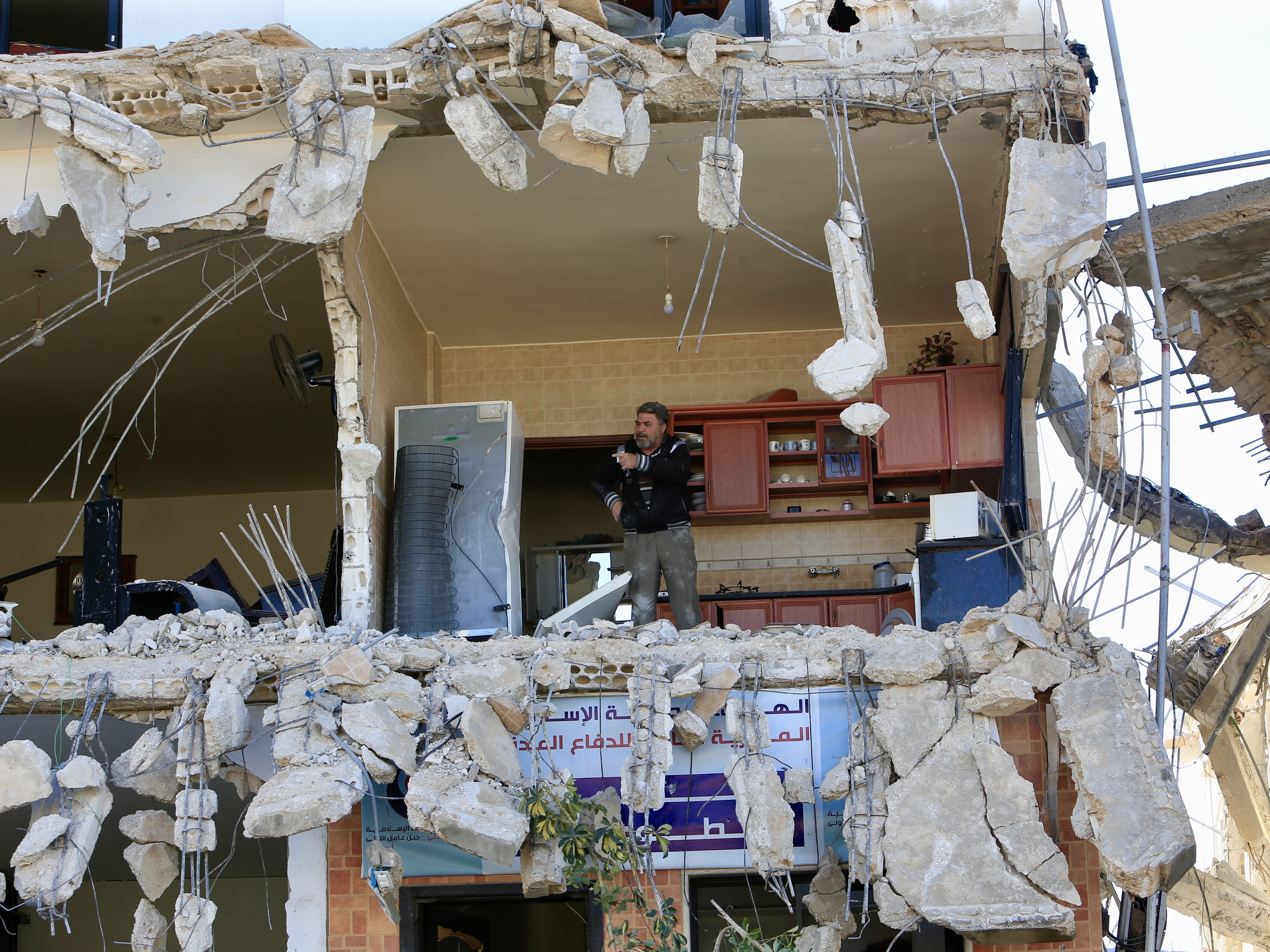 caption: Lebanese citizens return to their homes heavily damaged by Israeli attacks, after Israeli forces withdraw from the area in An-Naqoura, Lebanon, on Thursday.