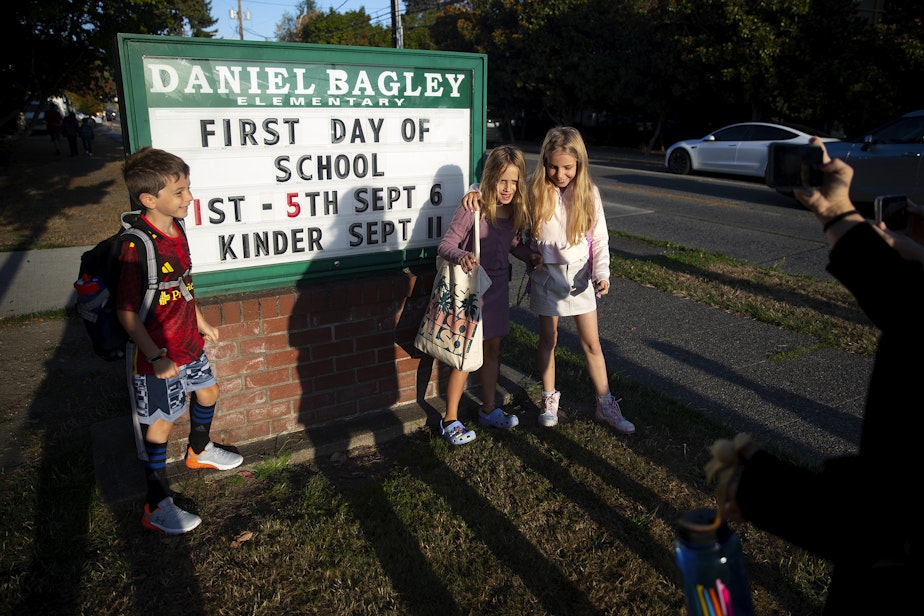 caption: From left, Maxwell Demas, 7, Gwen Yerkan, 9, and Hazel Demas, 9, take a picture before their first day of school on Wednesday, September 6, 2023, at Daniel Bagley Elementary School in Seattle. 