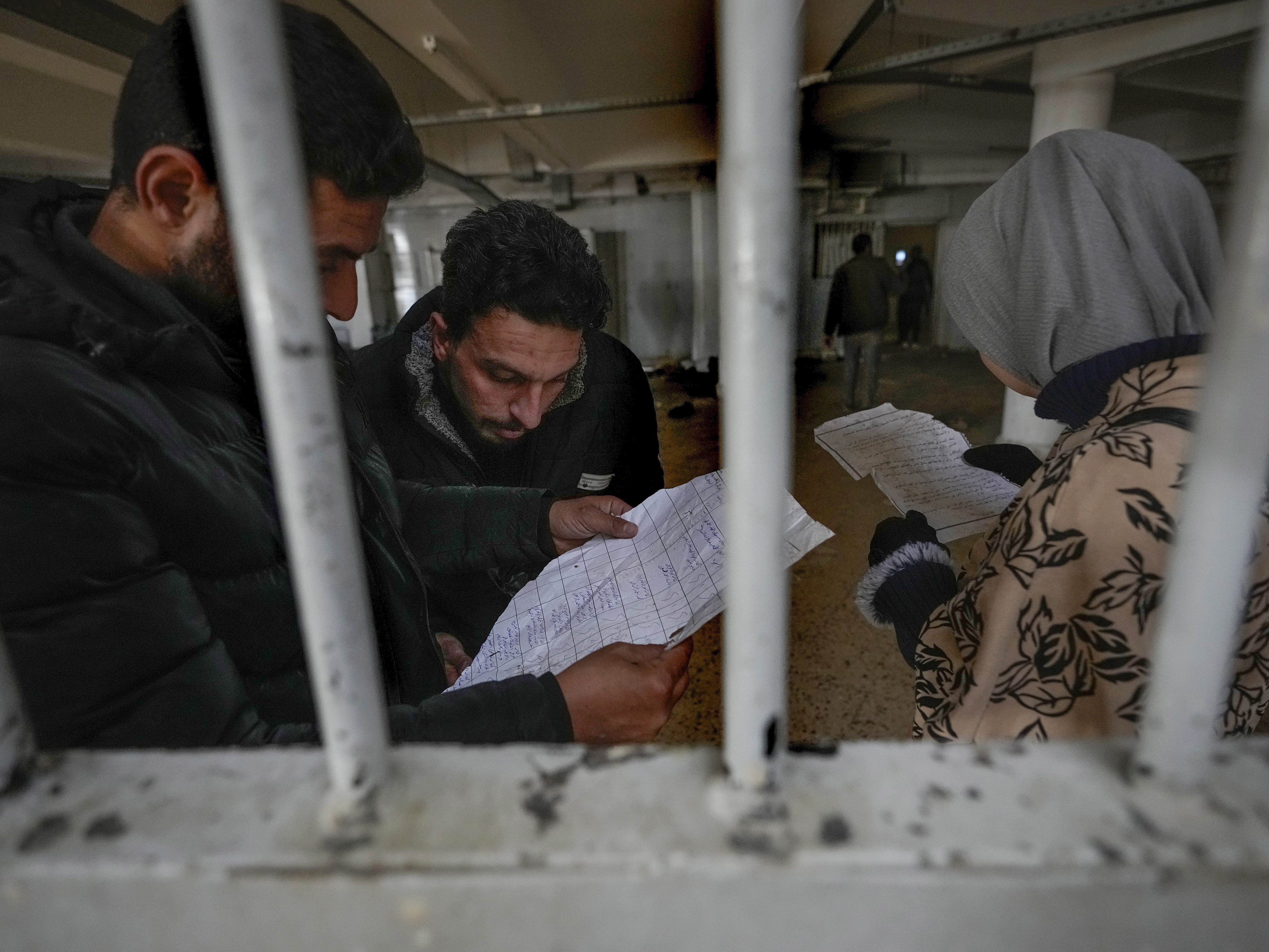 caption: Syrians inspect documents in the infamous Saydnaya prison, just north of Damascus, on Monday. Crowds are entering the prison, known as the "human slaughterhouse," following the ouster of Bashar al-Assad and the release of thousands of prisoners who were held by the regime.