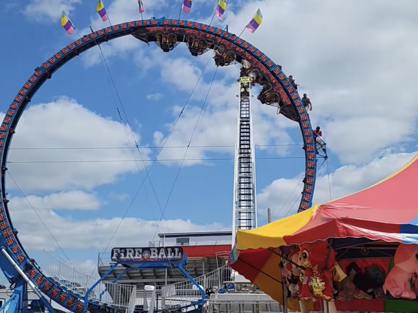 caption: Videos posted to social media showed ride operators desperately trying to free the stuck Fireball Roller Coaster Sunday in Crandon, Wis.