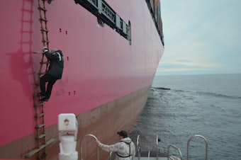 caption: A Puget Sound pilot disembarks from a containership.