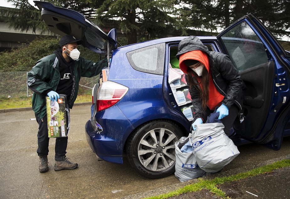 caption: Cass and Joscelyn DuVani deliver tents, sleeping bags, shoes, hot soup, cookies, portable power packs, tarps, clothing, and several other items to unhoused community members on Friday, March 5, 2021, near the intersection of 10th Avenue South and South Dearborn Street in Seattle.