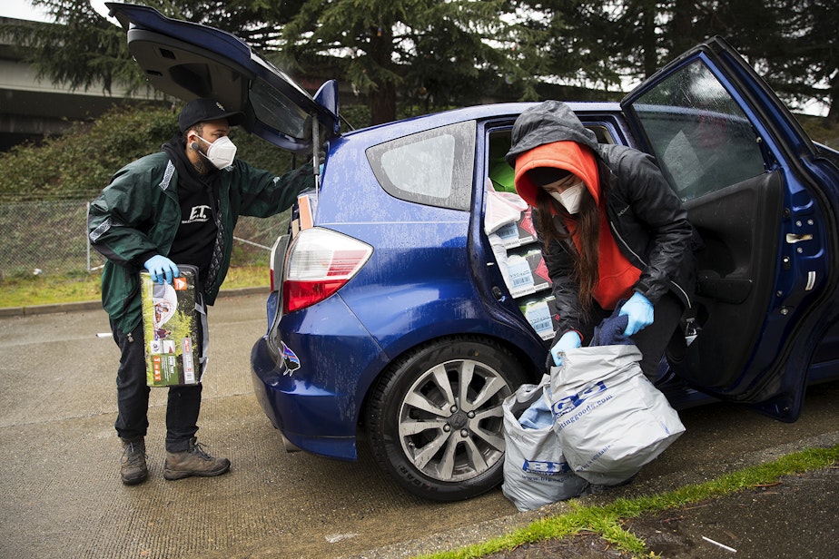 caption: Cass and Joscelyn DuVani deliver tents, sleeping bags, shoes, hot soup, cookies, portable power packs, tarps,  clothing, and several other items to unhoused community members on Friday, March 5, 2021, near the intersection of 10th Avenue South and South Dearborn Street in Seattle. 