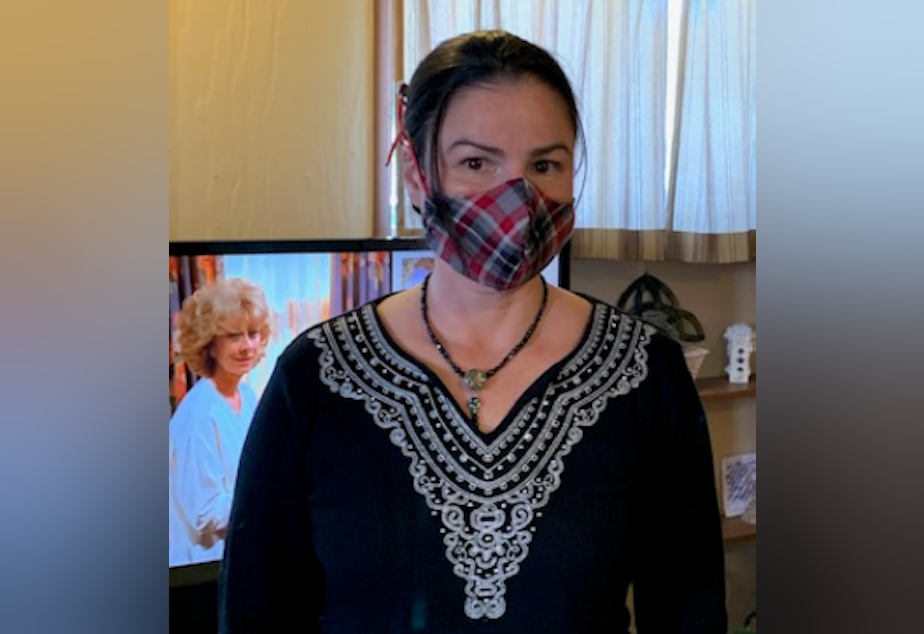 caption: Psychiatric social worker Maria Claudio shows off one of the homemade masks she's made for herself and co-workers at Western State Hospital.