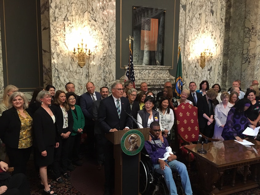 caption: Washington Gov. Jay Inslee signed two historic bills into law on Monday. One creates a public health insurance option, the other a new long-term care benefit.