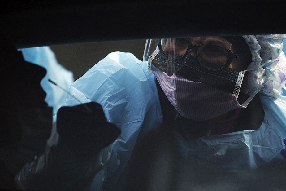 caption: A UW Medicine patient is tested for coronavirus by a UW Medicine nurse on Tuesday, March 17, 2020, at the University of Washington Northwest Outpatient Medical Center on Meridian Avenue North in Seattle. 