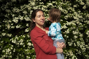 caption: Sonia Dillane holds her 21-month-old daughter at Webster Park on Tuesday, May 23, 2023, in Seattle. 