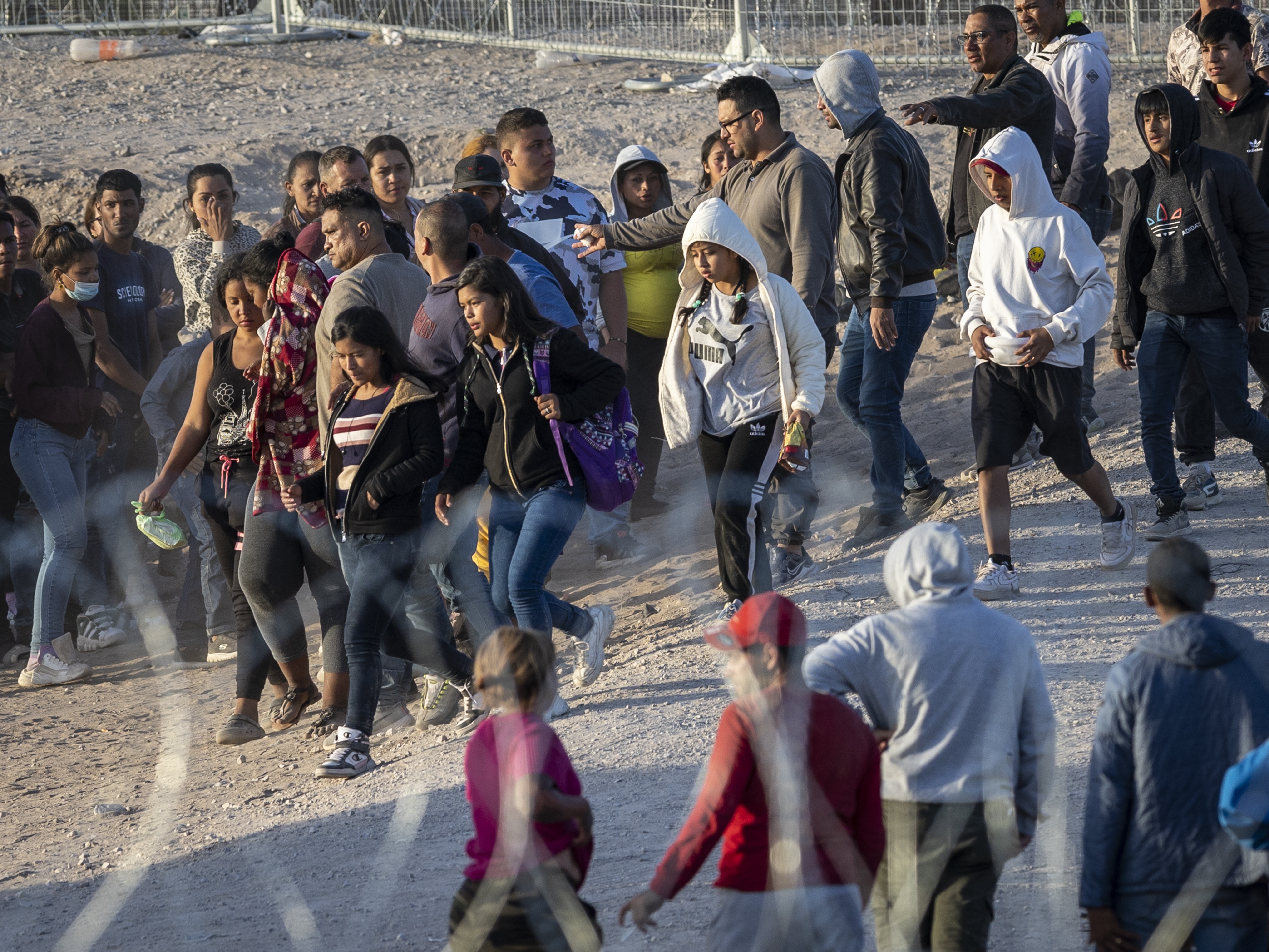 caption: Unaccompanied minors walk towards U.S. Border Patrol vehicles after crossing over from Mexico on May 09, 2023, in El Paso, Texas.