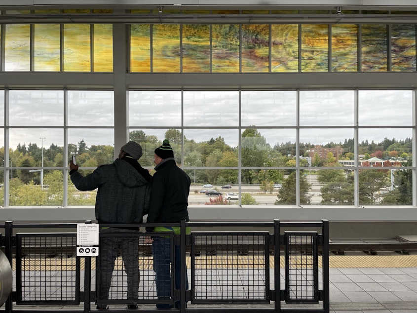 caption: A portion of Mary Ann Peter's long, horizontal art glass piece is visible here at Northgate Station