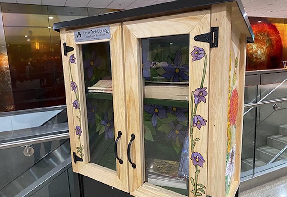caption: A little free library by artist Elizabeth R. Gahan, placed at Sea-Tac Airport. 