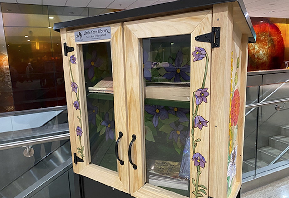 caption: A little free library by artist Elizabeth R. Gahan, placed at Sea-Tac Airport.