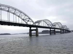 caption: The Centennial Bridge over the Mississippi River connecting Davenport, Iowa and Rock Island, Illinois. Davenport's downtown suffered millions of dollars in lost business after flooding last year.