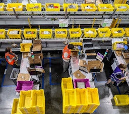 caption: Amazon employees sort packages at a new warehouse in Arlington, Washington.