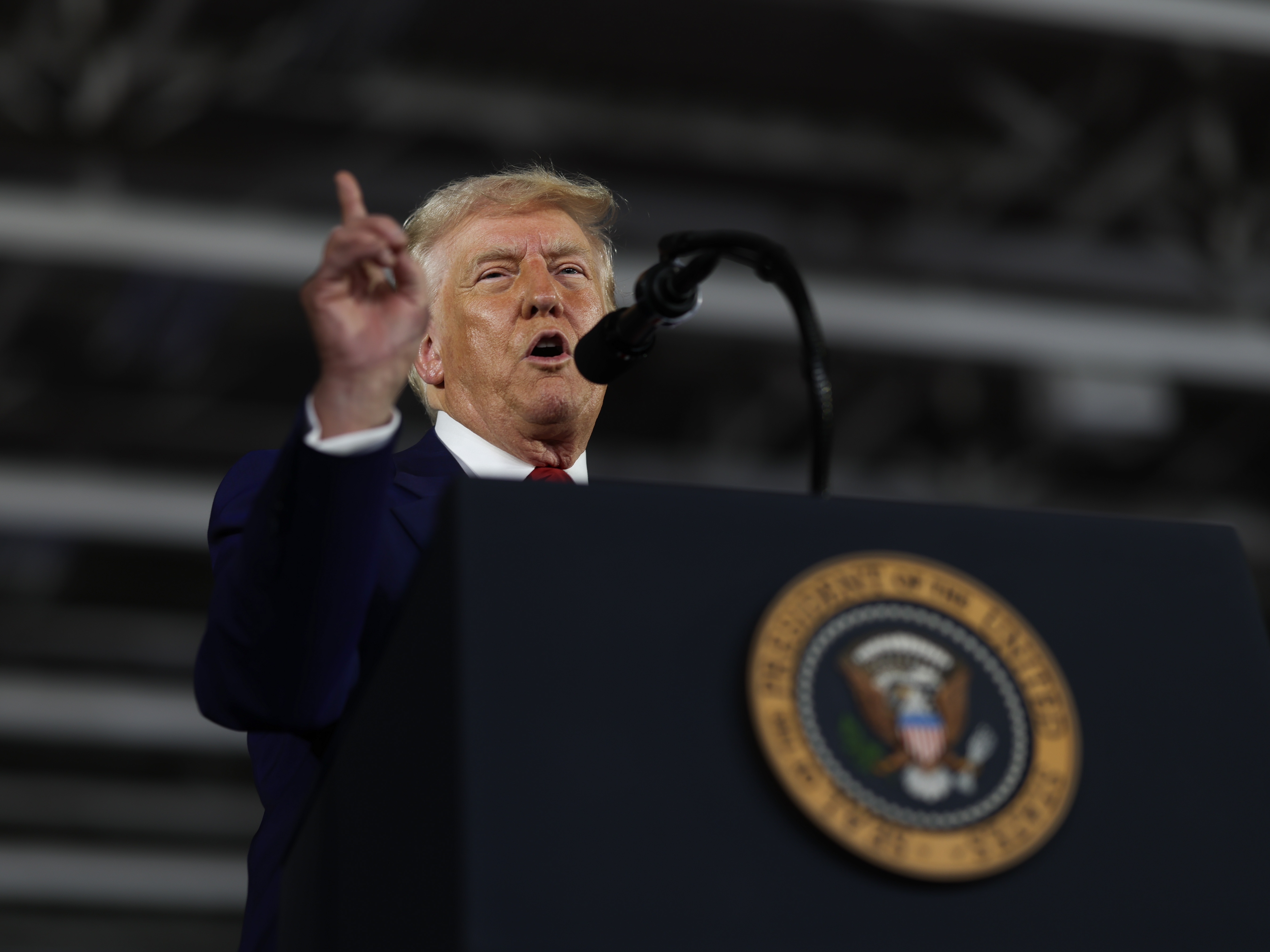 caption: President Trump speaks during a rally at Macomb Community College on in Warren, Mich., on Tuesday to mark his first 100 days in office.