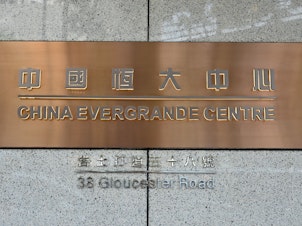 caption: A sign for the China Evergrande Centre building, the Hong Kong home for China Evergrande Group, is shown in the Asian city on Sept. 15. Fears of a debt default at the property developer has sparked a global stock market sell-off on Monday.