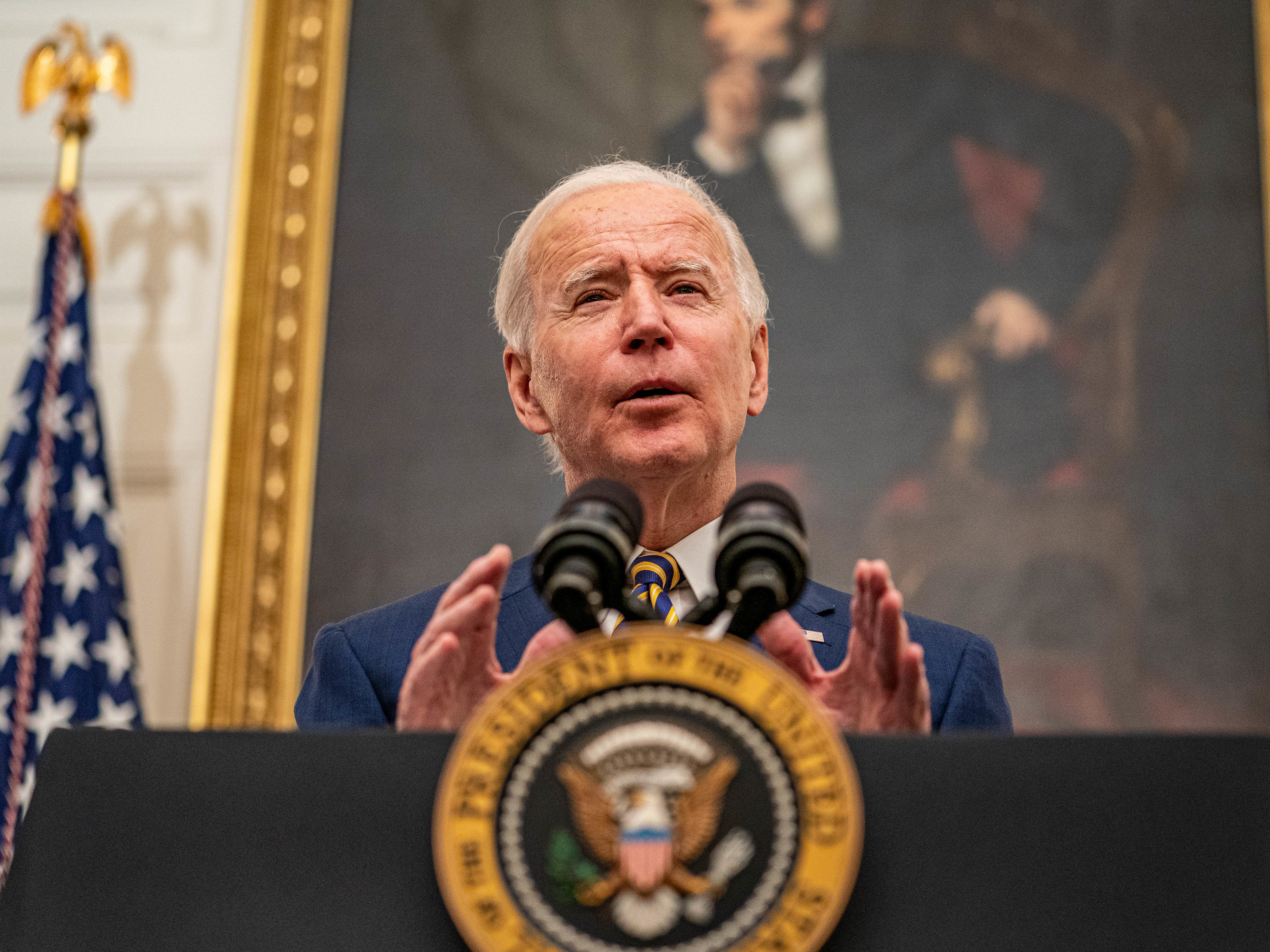 caption: President Biden speaks on his administration's response to the economic crisis in the State Dining Room of the White House on Friday.