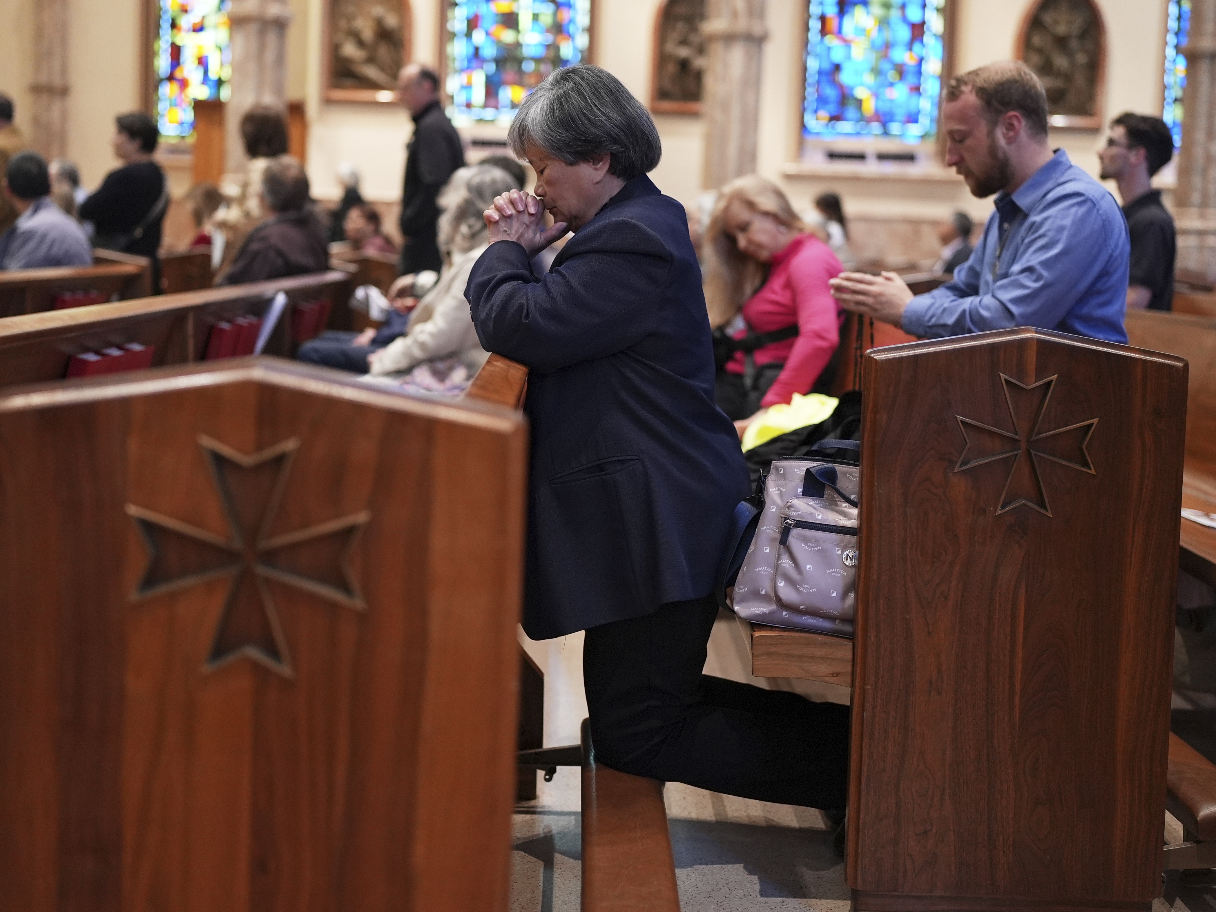 caption: Parishioners pray during a mass at Holy Name Cathedral in Chicago on Sunday.