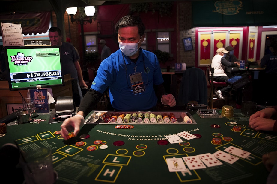 caption: Phuoc N. deals pai gow poker on Tuesday, May 17, 2022, at the Great American Casino in Tukwila. 