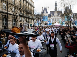 caption: Servers take off for the "<em>Course des Cafes</em>" in front of City Hall in central Paris on Sunday.