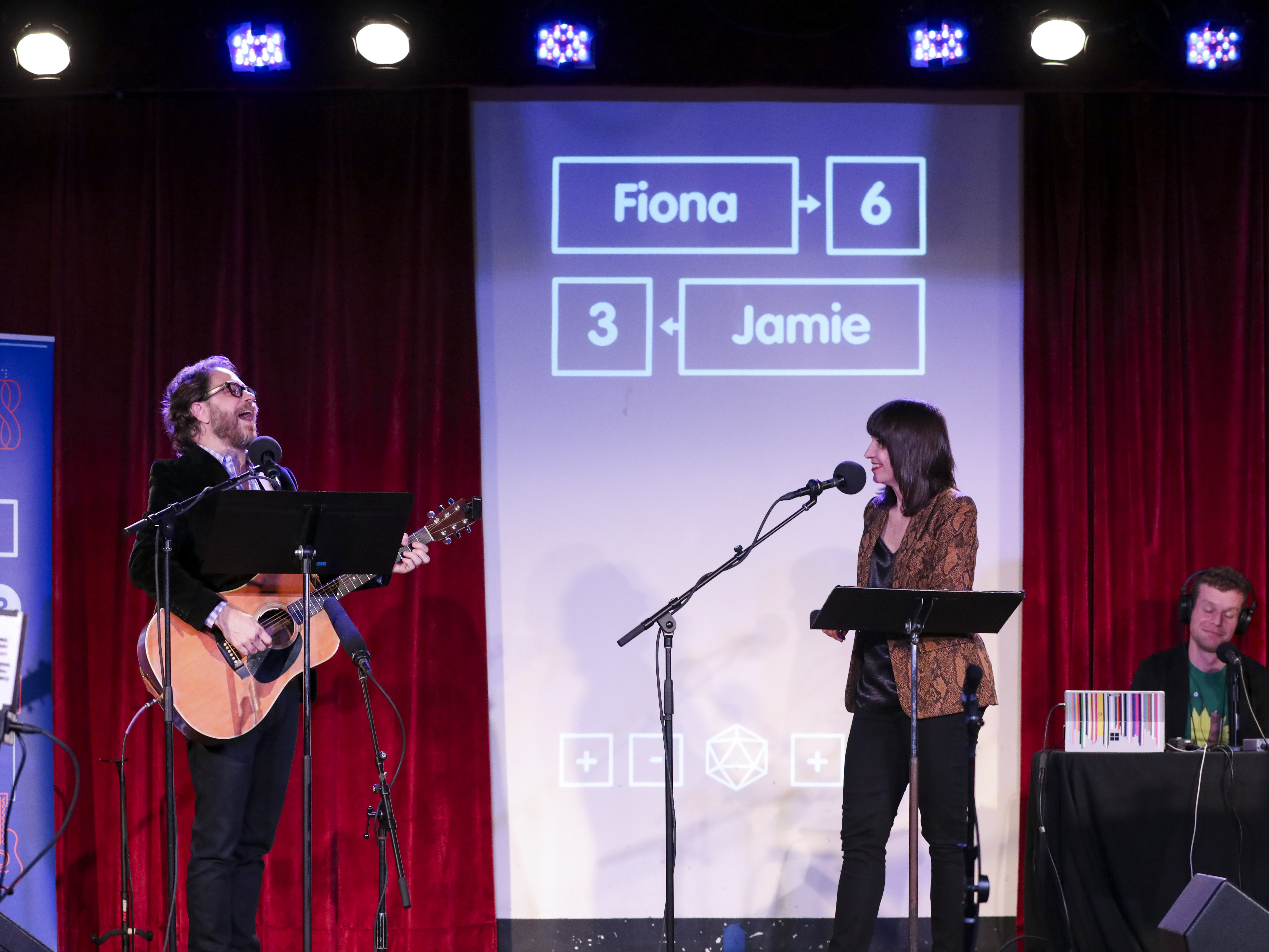 caption: Jonathan Coulton leads a music parody game alongside Ophira Eisenberg on <em>Ask Me Another</em> at the Bell House in Brooklyn, New York.