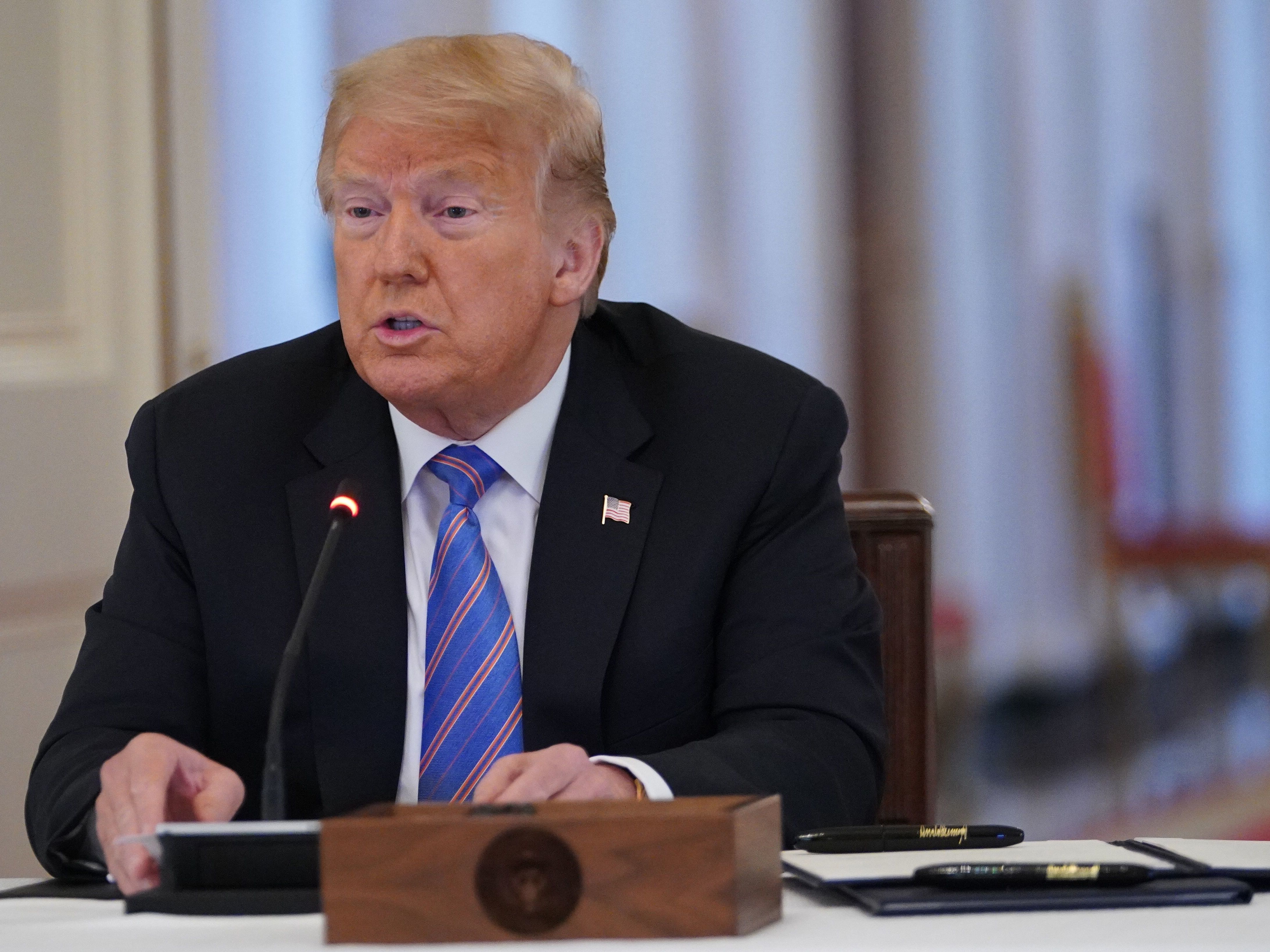 caption: President Trump, seen here during a workforce policy board meeting in June, has dismissed reports on Russian bounties on coalition forces in Afghanistan as a "hoax."
