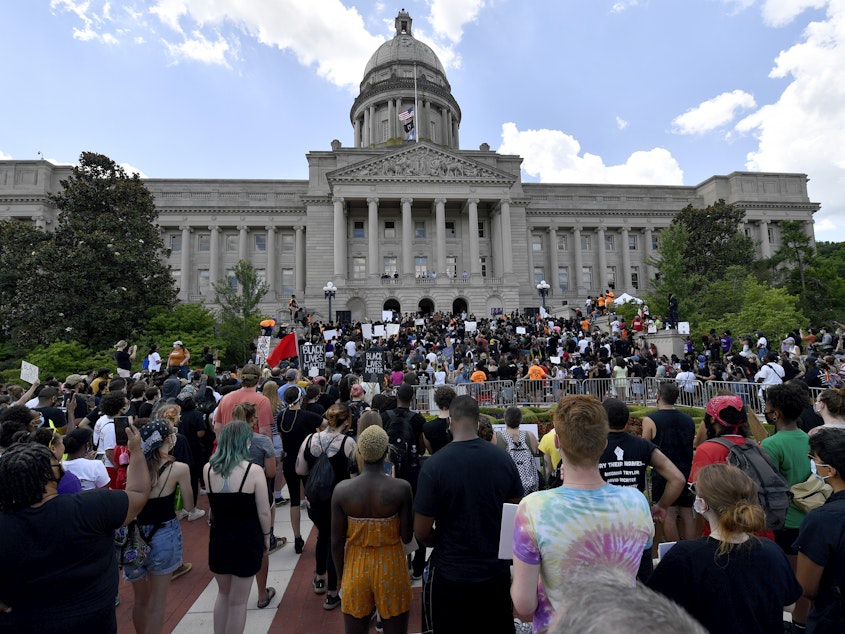 caption: A crowd gathers for a rally to demand justice in the death of Breonna Taylor on the steps of the the Kentucky State Capitol in June. Taylor was killed in her apartment while Louisville police served a warrant.