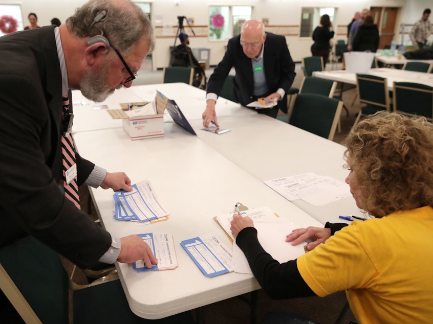 caption: Presidential preference cards are counted at a caucus at West Des Moines Christian Church in Iowa on Monday. Problems with a smartphone app designed to report the caucus results ended up delaying an official count.