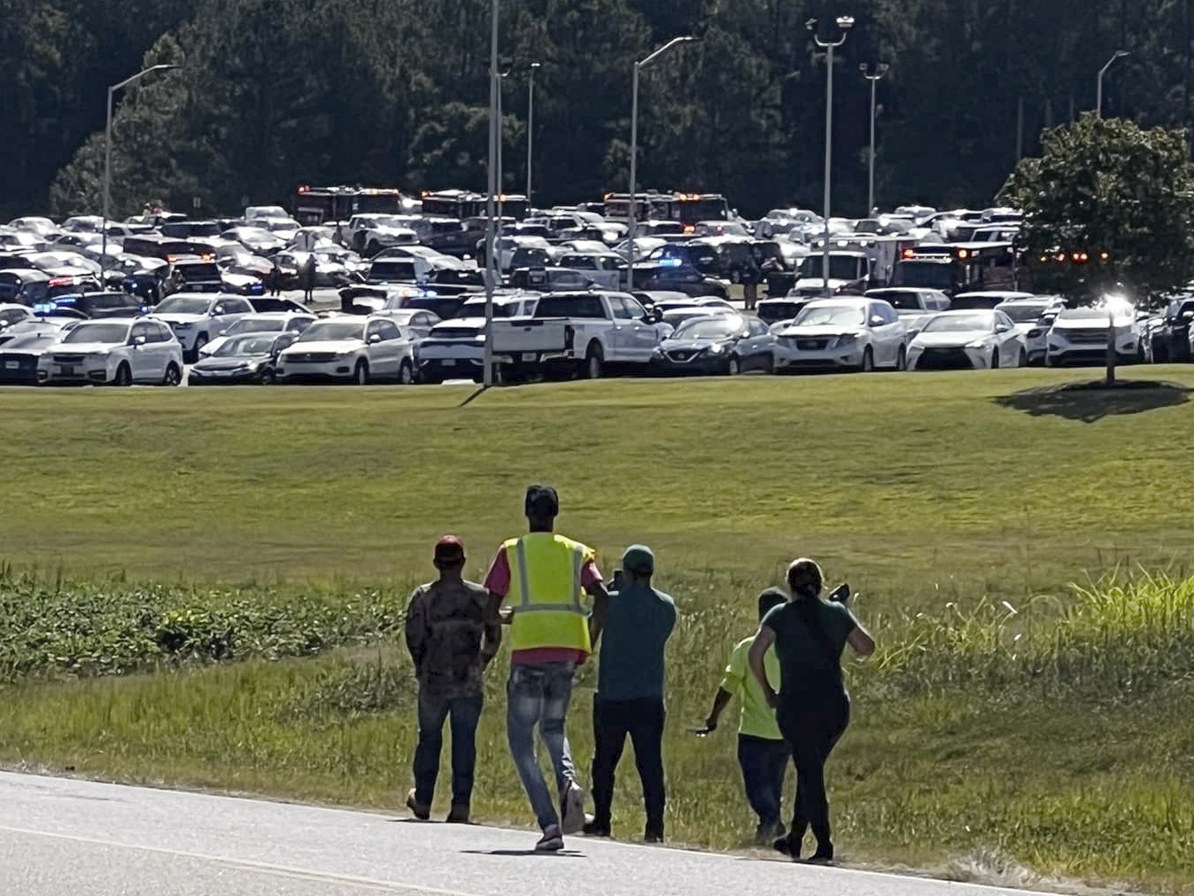 caption: Students are evacuated to the football stadium after the school campus was placed on lockdown at Apalachee High School in Winder, Ga., on Wednesday.