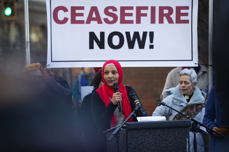 caption: Aneelah Afzali speaks to a crowd gathered for a multifaith solidarity gathering, calling for an immediate cease-fire in Gaza, on Thursday, November 16, 2023, outside of the Henry M. Jackson Federal Building in Seattle.