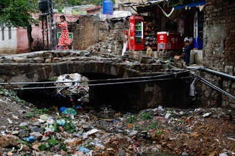 caption: The river that once snaked through the village is now a large trash heap.