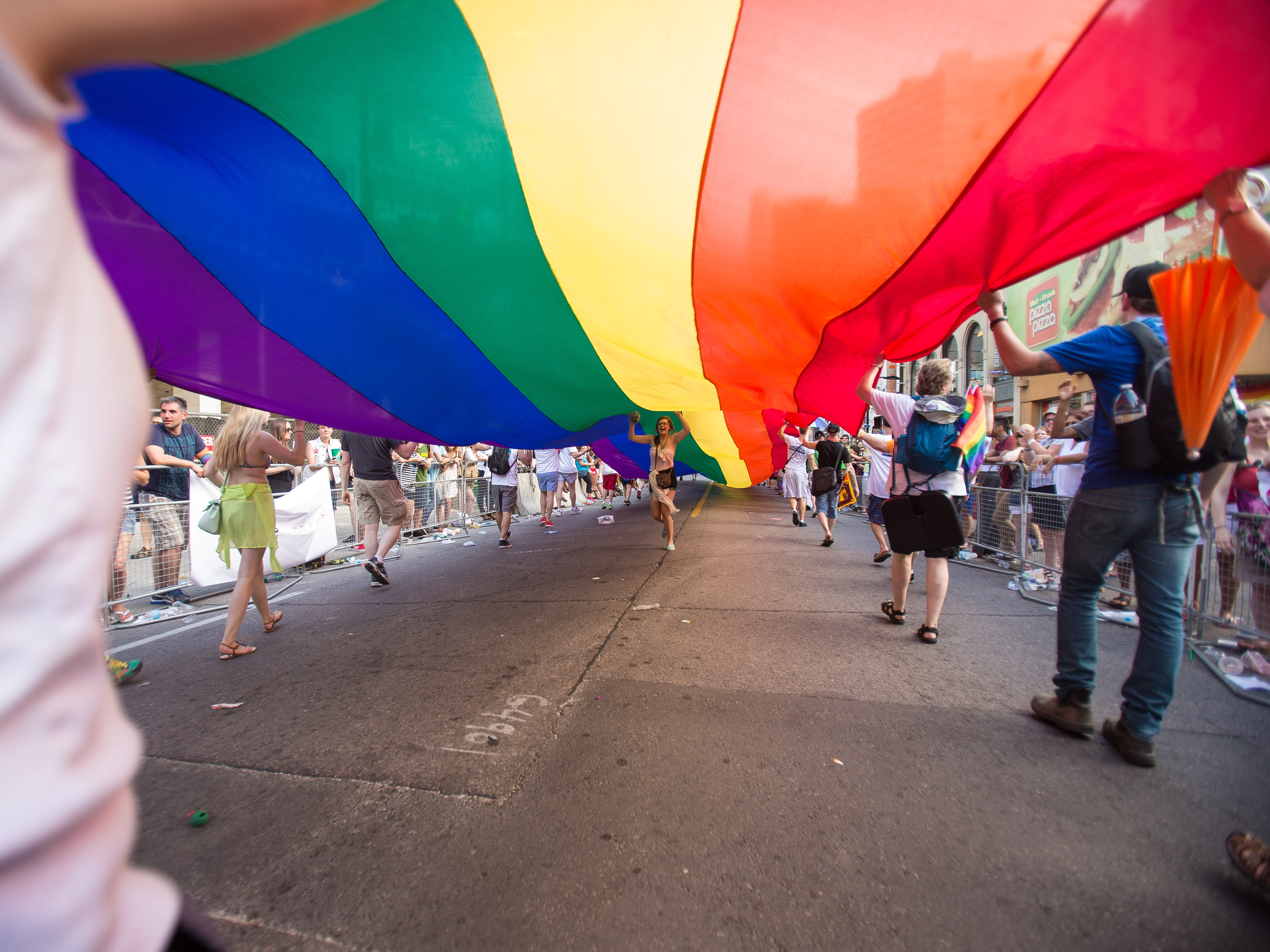 caption: People carry a rainbow flag at the WorldPride 2014 Parade in Toronto in 2014.