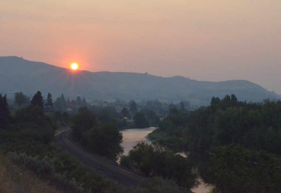 caption: Wildfire smoke blankets the Wenatchee area at sunset recently.