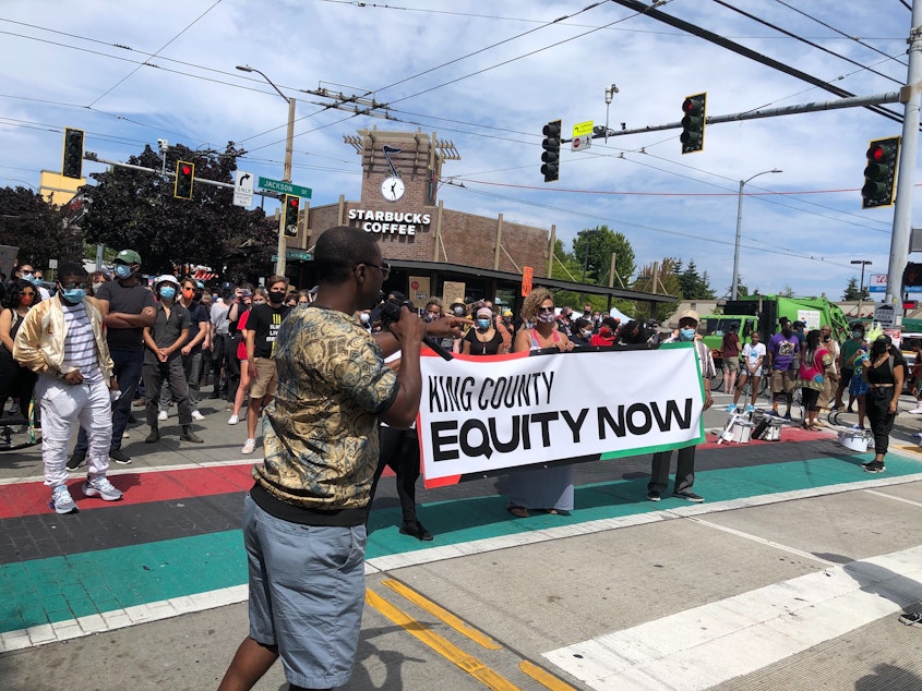 caption: During the Umoja Fest march, Wyking Garrett called for more support for Black-owned businesses at 23rd and Jackson. 