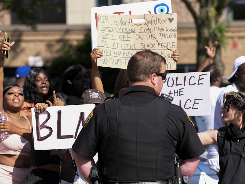 caption: Demonstrators standoff with officers outside Akron City Hall on Sunday as they protest the fatal police shooting of Jayland Walker.