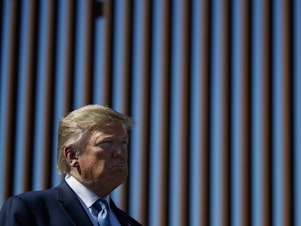 caption: President Trump tours a section of the southern border wall in 2019, in Otay Mesa, Calif.