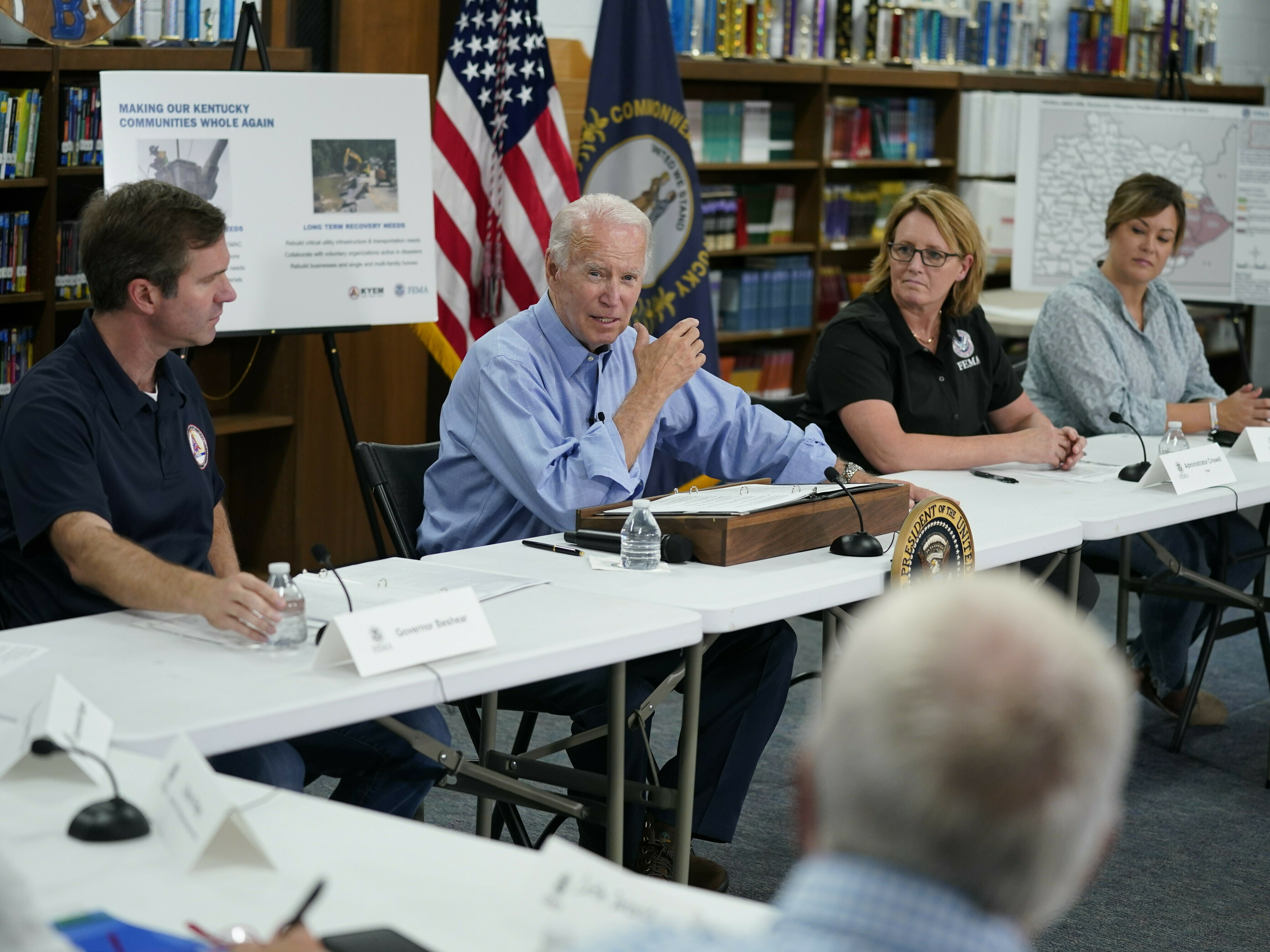 caption: President Biden gets a briefing in Lost Creek, Ky., after touring flood damage. He vowed that communities in the state would get help to rebuild after the disaster.