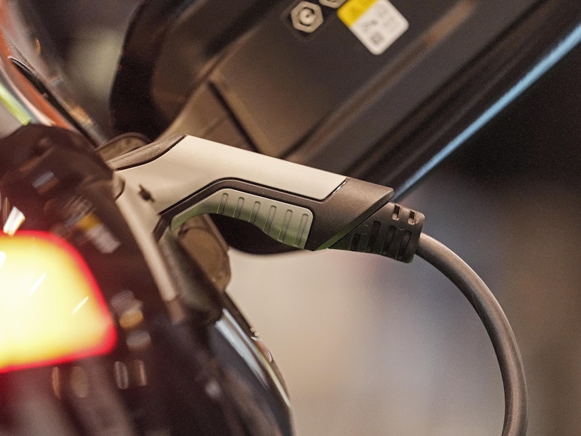 caption: An electric car is charged at the Motor Show in Essen, Germany, Thursday, Dec. 2, 2021. Charging may soon be easier across the U.S. with seven car companies banding together to create a charging network.