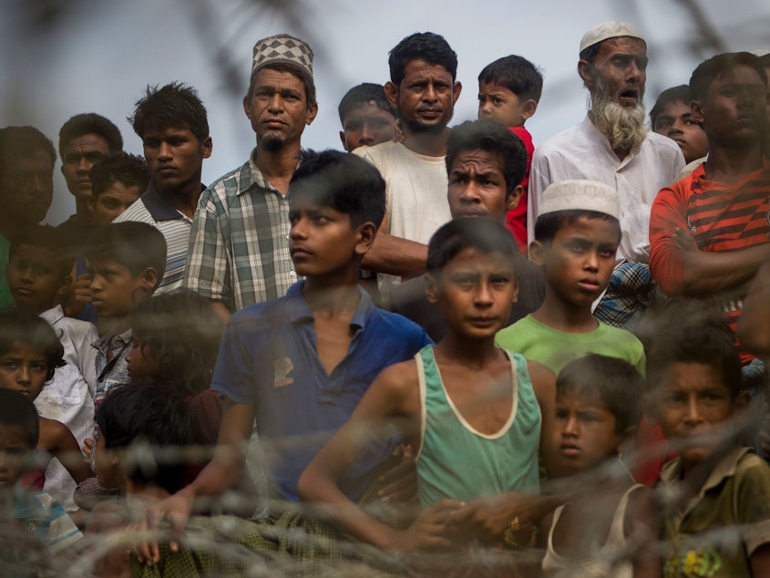 caption: Rohingya refugees gather in the "no man's land" behind Myanmar's barbed-wire-lined border in Maungdaw district, Rakhine state, in 2018. Some 700,000 refugees fled into Bangladesh following a brutal crackdown by the Myanmar military in 2017.