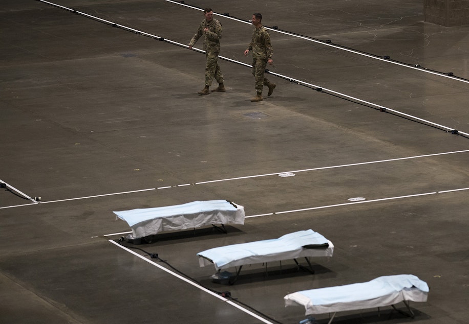 caption: U.S. Army soldiers from the 627th Army Hospital from Fort Carson, Colorado, as well as from Joint Base Lewis-McChord set up a 250-bed military field hospital for non COVID-19 patients on Tuesday, March 31, 2020, at the CenturyLink Field Event Center in Seattle.