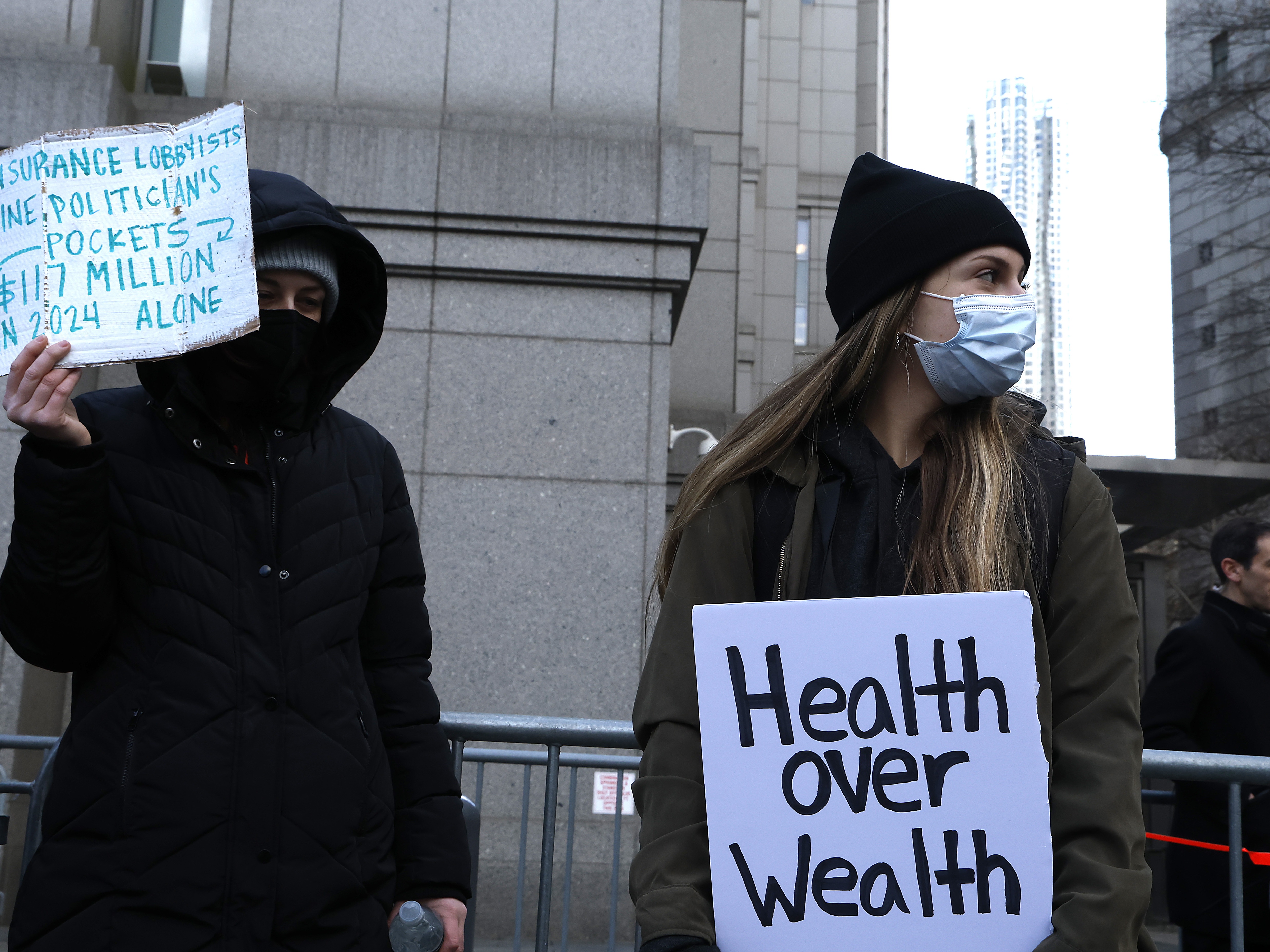 caption: People demonstrating against the health care industry stand outside Federal Criminal Court as Luigi Mangione, suspect in the shooting death of UnitedHealthcare CEO Brian Thompson, appears during an arraignment hearing on Dec. 19, 2024 in New York City.