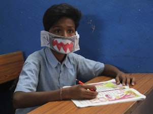 caption: An Indian student wears a self-made mask during class in Hyderabad, India, on Wednesday. The country has reported at least 29 cases of the virus.