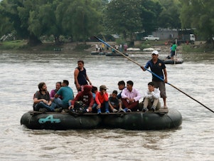 caption: Central American migrants use a makeshift raft across the Suchiate River from Tecún Umán in Guatemala to Ciudad Hidalgo in Chiapas state, Mexico, on June 11.