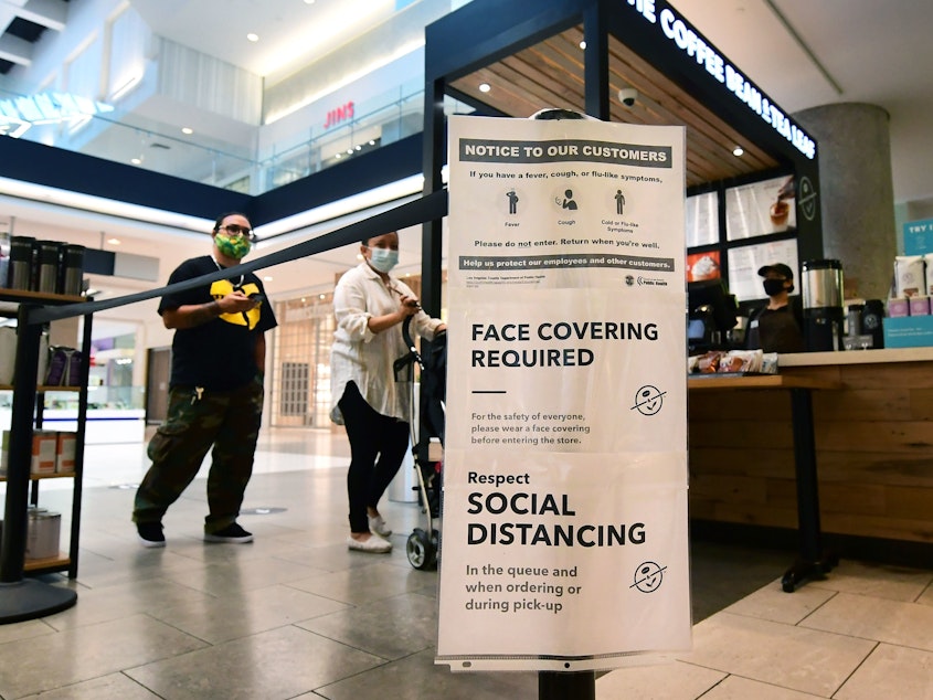 caption: Social distancing instructions are seen at California's Westfield Santa Anita shopping mall on June 12, as local businesses enter Phase 3 reopening.