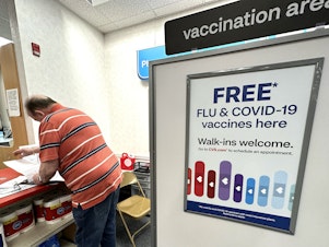caption: Flu and COVID-19 vaccinations are now available across the U.S., including at this CVS pharmacy in Palatine, Illinois.